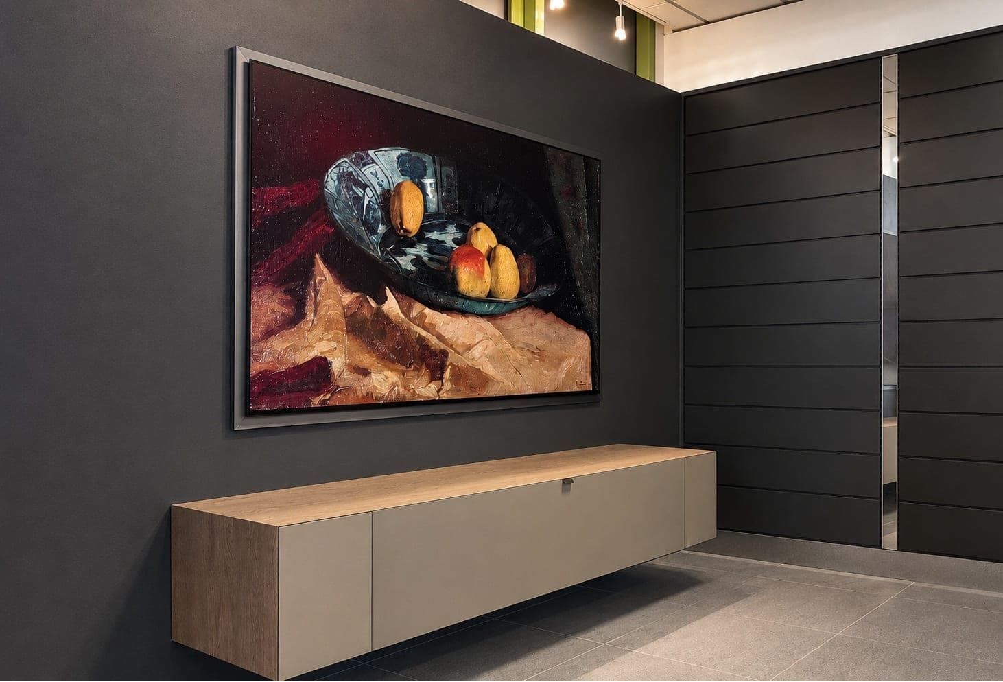 Wand-TV mit Kunstmotiv über schwebendem Lowboard an der dunklen Möbelwand im Showroom